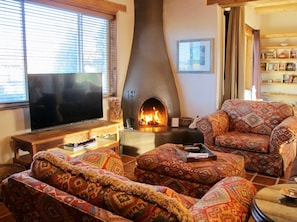 The spacious living area features a wood-burning kiva fireplace.