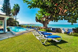 Sun kissed lounging by pool in front garden with magnificent ocean views