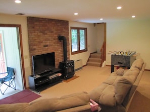 Lower level living area.  Foosball, TV, Stove, 2 bedrooms, full bath, patio ...