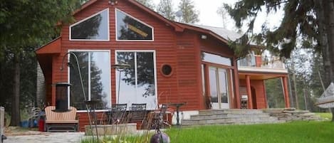 Apple Unit with large windows towards the water, outside patio with a fire pit