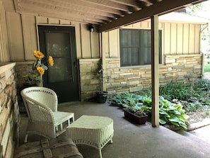 Covered front porch w seating area. Enjoy the front garden and quiet atmosphere.