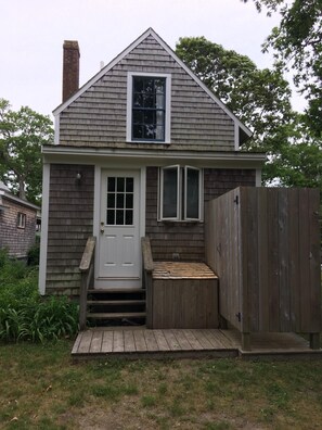 Back of house with private outdoor shower and storage box for beach chairs etc.