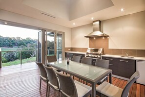 Host unforgettable alfresco dinners in the covered outdoor entertaining area, featuring a BBQ, dining table, and an outdoor kitchen—all with sweeping valley views.
