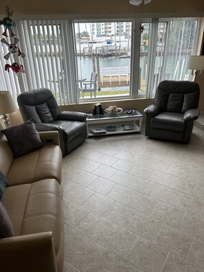 Den area with 65 inch tv and 180 view of water