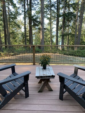 Large front deck facing Mud Bay, water view through the trees, Adirondack chairs