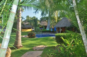 View of Villas Blancas common area with pool, fiesta palapa and grounds.