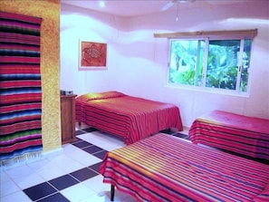 Bedroom with queen and twin beds, with rainforest courtyard view