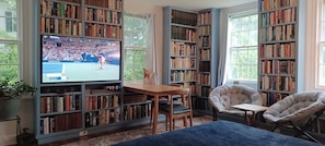 Southwest view:  60" television built into bookcase and adjacent dining are