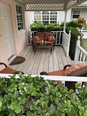 North facing porch with love seat, coffee table and 2 lounge chairs 