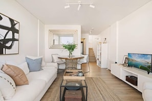 Another angle of the living space showing stairways to the bedroom