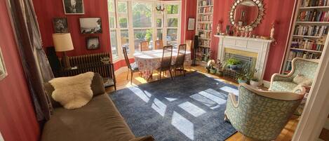 Front living room, light-filled, ready to host meals, a relaxing read, or a nap!