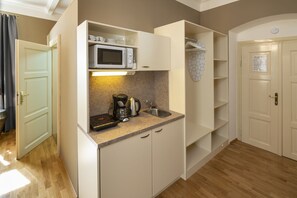 Kitchenette with basic kitchen utensils and fridge with freezer