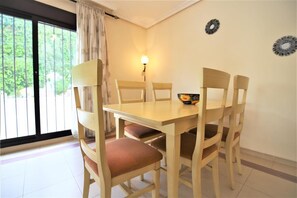 Dining area for four guests with swimming pool views