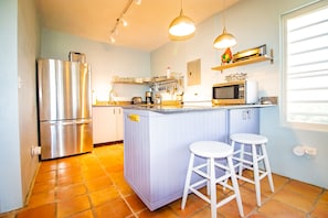 Upstairs Kitchen overlooks pool and extends to screened in porch