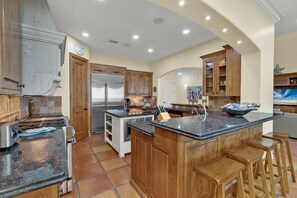 Modern kitchen with stainless steel appliances and fully stocked with kitchen wares.