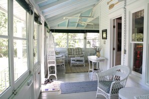 Spacious porch with antique wicker . . . perfect for reading and people watching