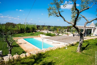 Trulli villa con piscina privada rodeada de matorral mediterráneo