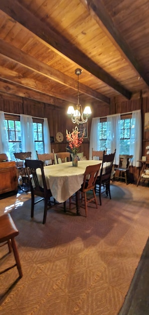 Bay windows partially surround large dining table in dining room off kitchen