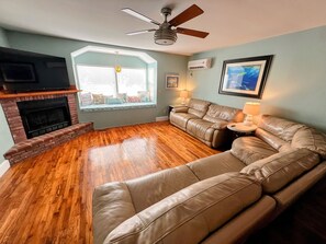 Living room with big screen tv and reclining couches