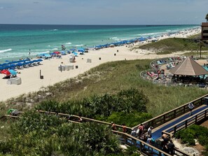 View to beach boardwalk + pool + tiki bar