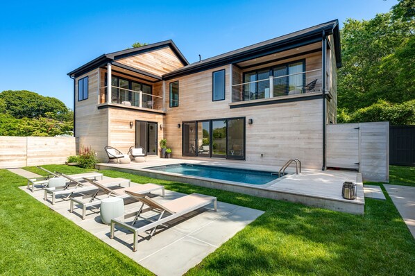 Salt water pool, outdoor shower, dining table, outdoor living room, grill.