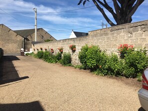 Grande cour fermée pour les enfants et parking.