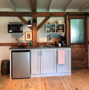 The kitchenette features custom cabinets and quartz counter top.  