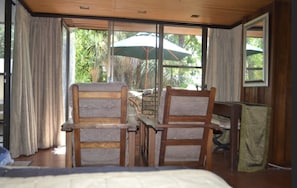 Comfortable chairs & chest overlooking private patio area surrounded by garden