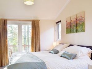 Welcoming bedroom with zip and link superkingsize bed and outdoor access | Oak Lodge, Clatworthy, near Williton