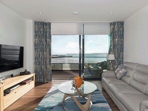 Tastefully furnished living area with patio doors leading to balcony | Bay View Abbey Sands, Torquay