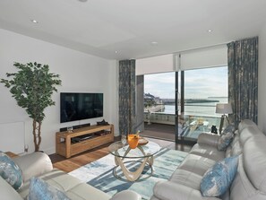 Tastefully furnished living area with patio doors leading to balcony | Bay View Abbey Sands, Torquay