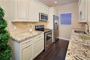 Beautiful kitchen with new appliances, hardwood cabinets, and fixtures.
