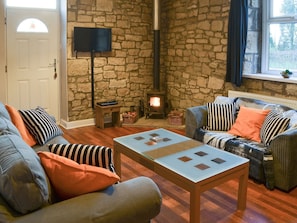 Charming living area with exposed stone walls and wood burner | Stable Cottage - Railway Cottages, Acklington, near Amble