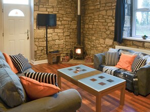 Charming living area with exposed stone walls and wood burner | Stable Cottage - Railway Cottages, Acklington, near Amble
