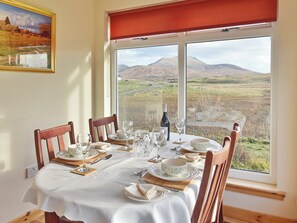 Sunny dining room with dramatic views of the hills | Padraig’s Cottage, Howbeg (Tobha Beag), Isle of South Uist