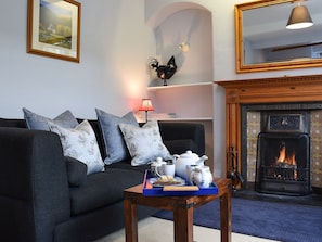 Cosy living room with open fire | Ardchoille Cottage, Fortingall, near Aberfeldy