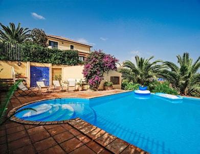 Villa con piscina, jardín y vistas al mar.