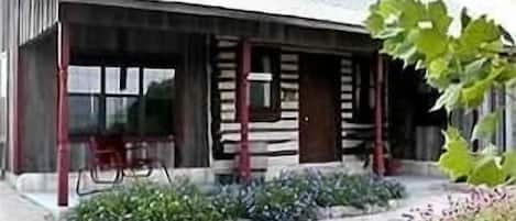 The front porch of Joy's Country Cabin overlooks a pond frequented by wildlife.