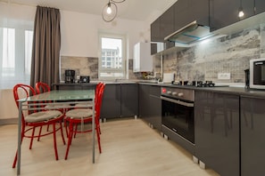 The kitchen has the oven refrigerator, coffe maker, toaster.