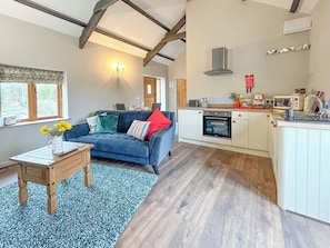 Stylish open-plan living space with original beams and high ceilings. | Nuthatch Barn - Little Derril, Derril, near Bude