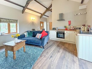 Stylish open-plan living space with original beams and high ceilings. | Nuthatch Barn - Little Derril, Derril, near Bude