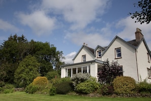 View of main farmhouseand dining conservatory from large mature gardens.