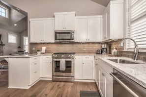 Gourmet kitchen open to dining and living area 