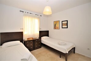 Second bedroom with two single beds and air conditioning