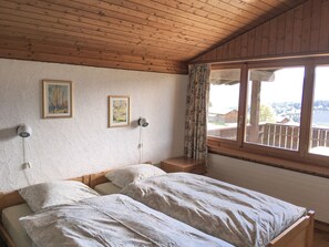 Grosses Schlafzimmer mit Aussicht auf Dorf und Berge