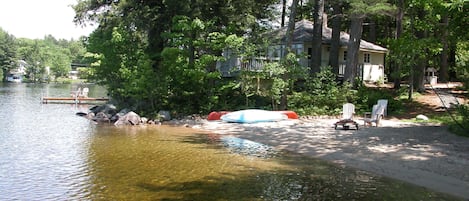 view of cottage showing the all sand beach, separate dock and lakefront deck