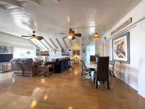Spacious open main Living/Dining Room with high ceiling and wood floors.