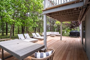 Expansive outdoor deck with glimpse of beach through the pines