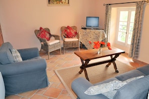 Living area of Tuzelle with large french windows, catherdral beamed ceilings.