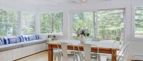 Open dining area w built-in bench seating, table for 6-8 & sliding doors to deck